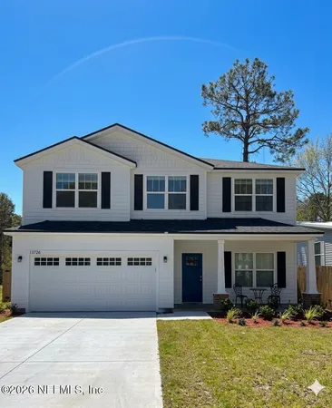 a front view of a house with a yard outdoor seating and garage