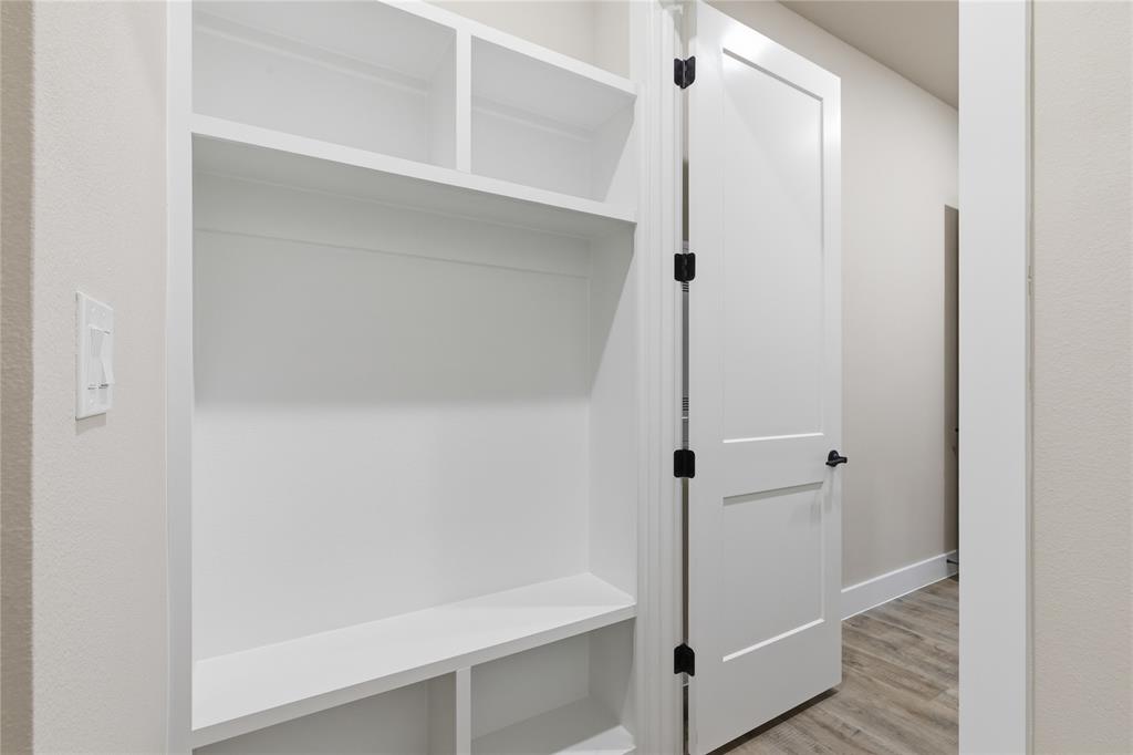 709 Anne Road Van Alstyne, TX 75495 - Photo 23 of 28 Built-in white shelving system featuring upper cubbies, a bench, and lower storage compartments