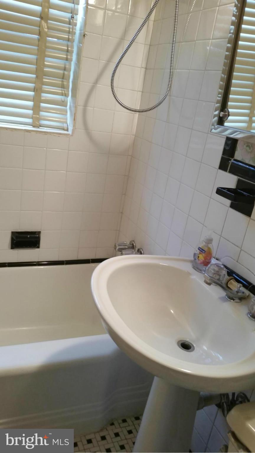 4636 Easy Place Southeast Washington, DC 20019 - Photo 23 of 29 a bathroom with a white bath tub and a sink