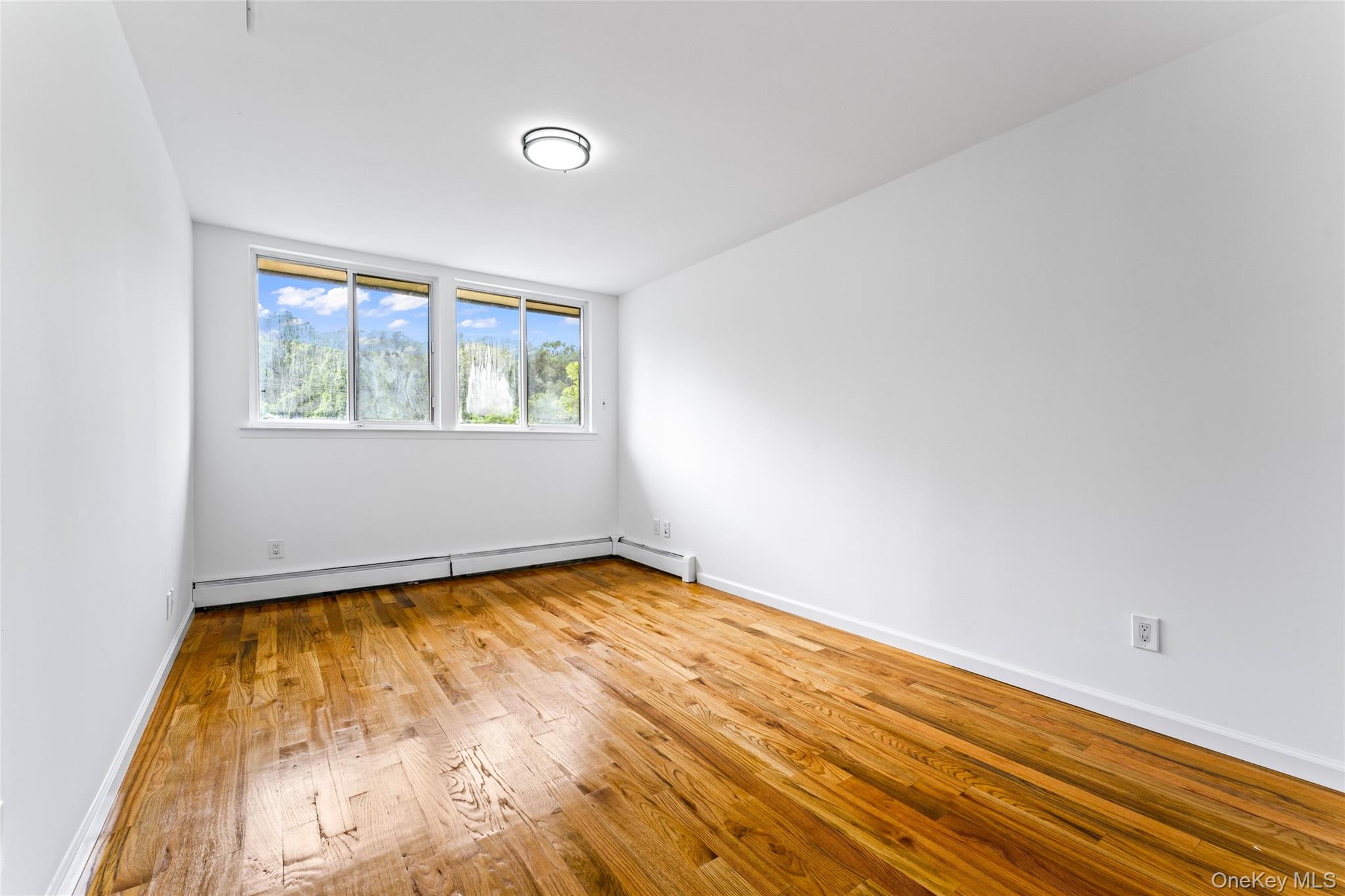 126 Bagatelle Road Melville, NY 11747 - Photo 24 of 50 a view of an empty room with wooden floor and a window