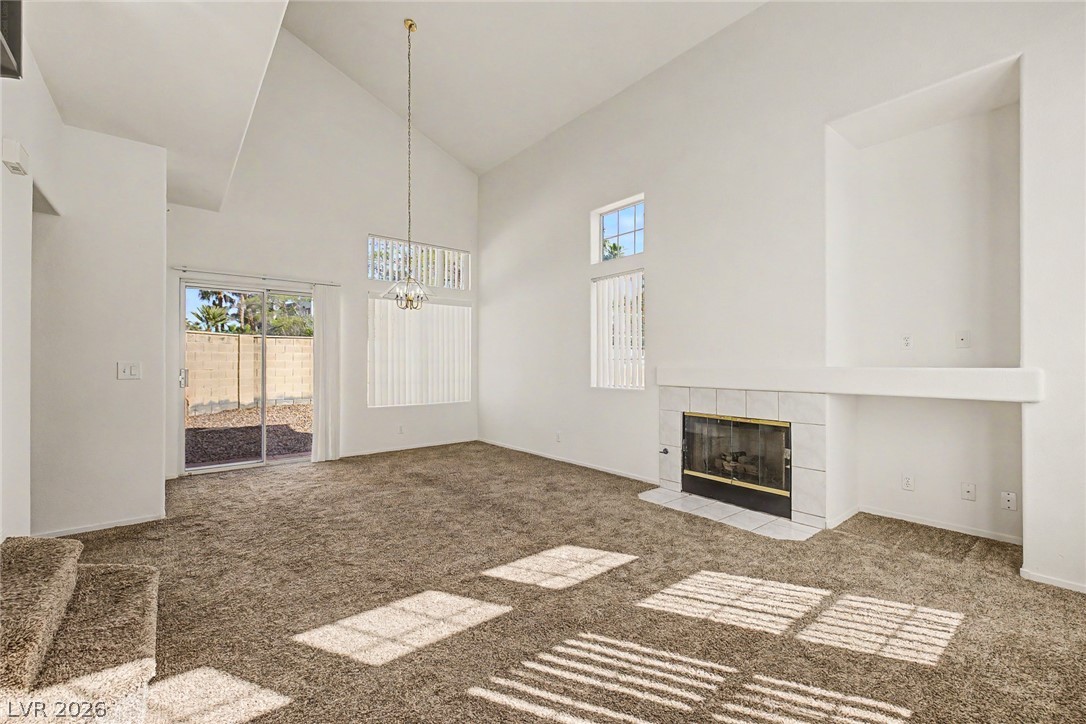 2223 Ramsgate Drive Henderson, NV 89074 - Photo 6 of 32 A spacious living area features high ceilings and a cozy fireplace, perfect for gatherings.