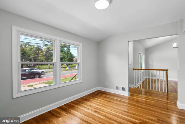 a view of a room with wooden floor and windows