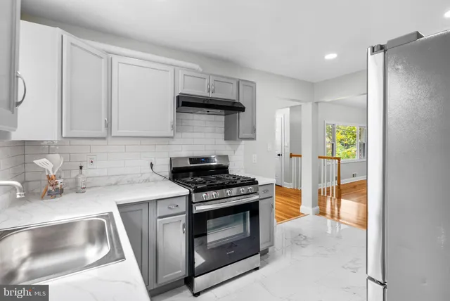 a kitchen with stainless steel appliances a stove a sink and a refrigerator