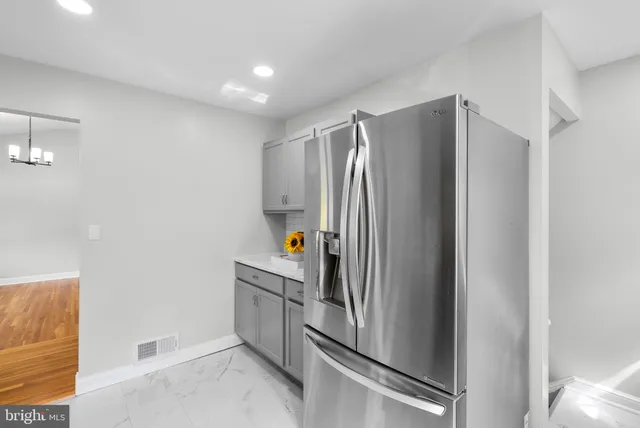 a room with stainless steel appliances a refrigerator and a cabinets