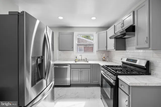 a kitchen with stainless steel appliances granite countertop a refrigerator sink and stove