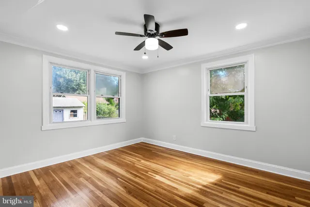 a view of empty room with window and ceiling fan