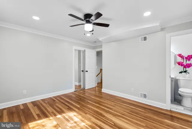 a view of a livingroom with wooden floor and a ceiling fan