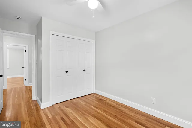 a view of a room with wooden floor and a ceiling fan