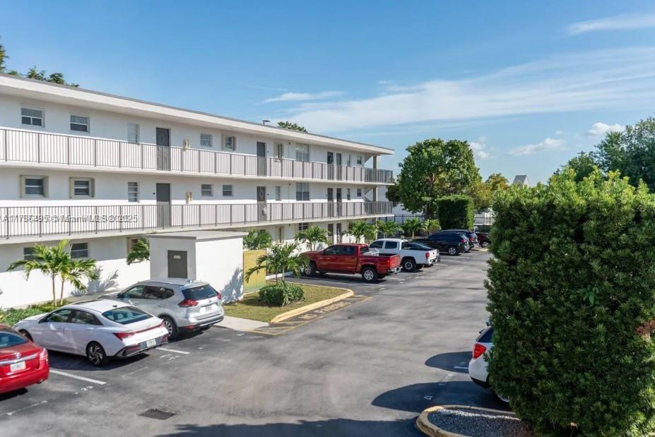 a view of a cars park in front of a building