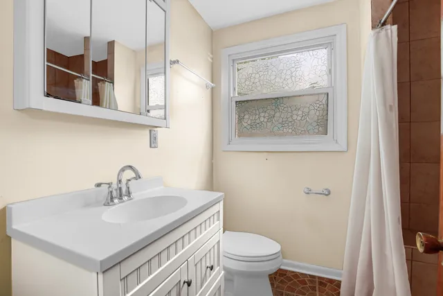 a bathroom with a sink a toilet and a window