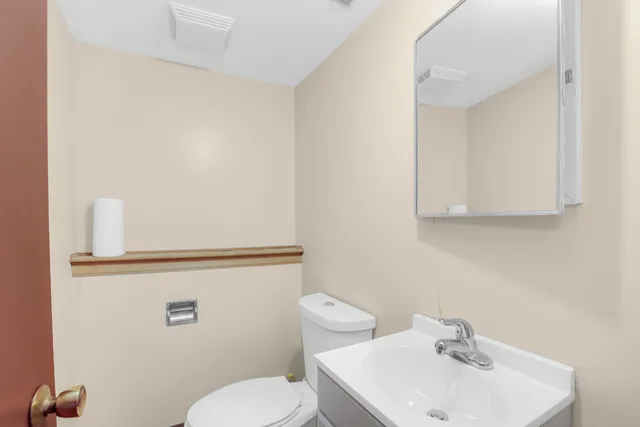 a bathroom with a sink a toilet and mirror