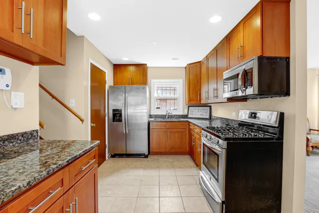 a kitchen with stainless steel appliances granite countertop a stove a sink and a microwave