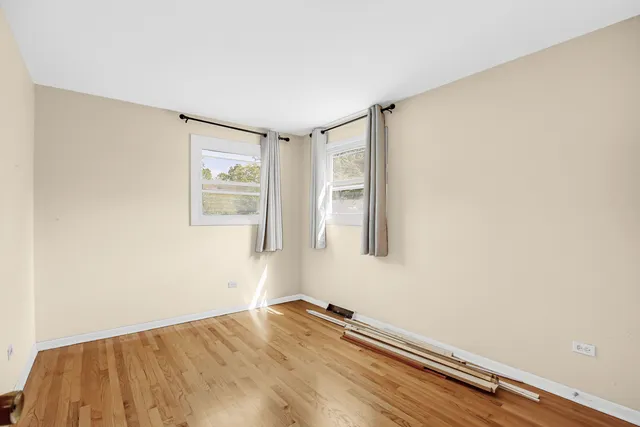a view of a room with wooden floor and a window