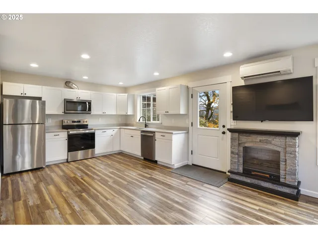 a open kitchen with granite countertop a stove top oven and refrigerator