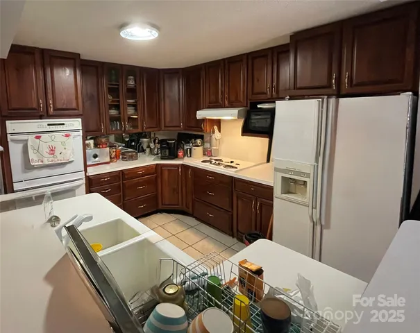 a kitchen with granite countertop wooden cabinets a refrigerator and a sink