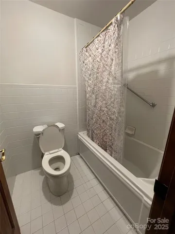 a bath room with a toilet and a shower
