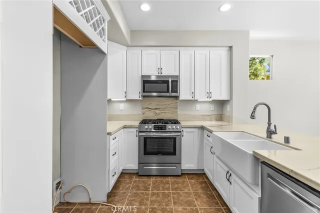 a kitchen with stainless steel appliances granite countertop a stove and a sink