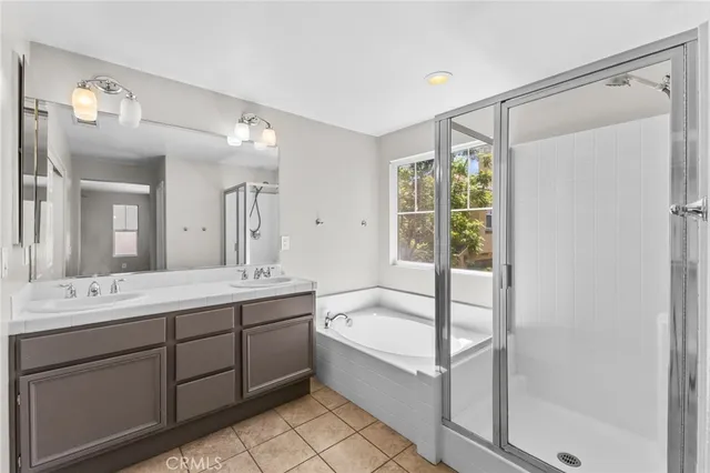 a spacious bathroom with a double vanity sink mirror and bathtub