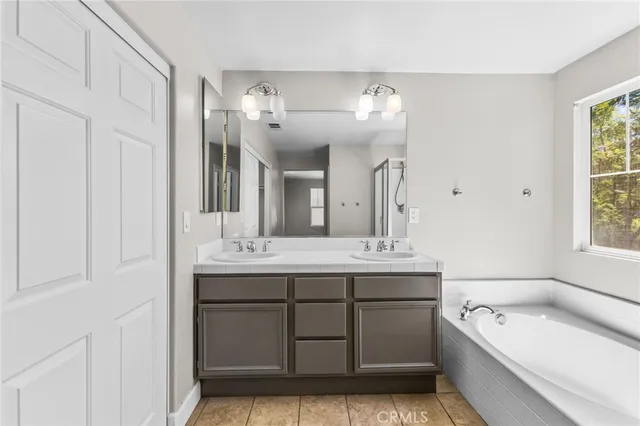 a spacious bathroom with a tub sink and mirror