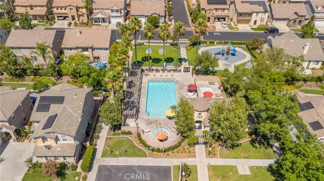 an aerial view of residential houses with outdoor space and parking
