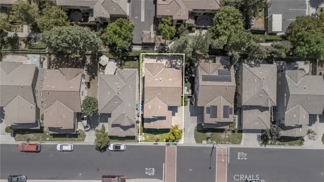 an aerial view of residential houses with outdoor space and street view