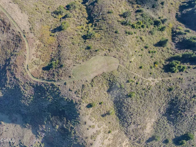 a view of a dry yard with wooden fence