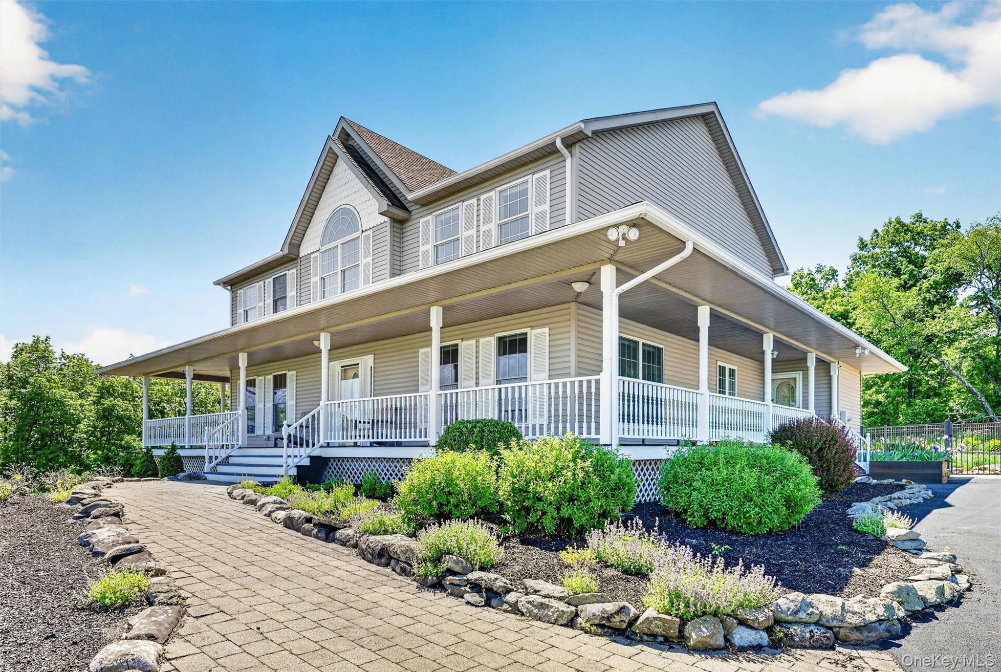 954 Ridgebury Road New Hampton, NY 10958 - Photo 5 of 45 The front walkway and wraparound porch create a warm welcome, offering the kind of entry that instantly feels like home. Beautifully manicured flower beds relfect how well this home has been cared for inside and out.