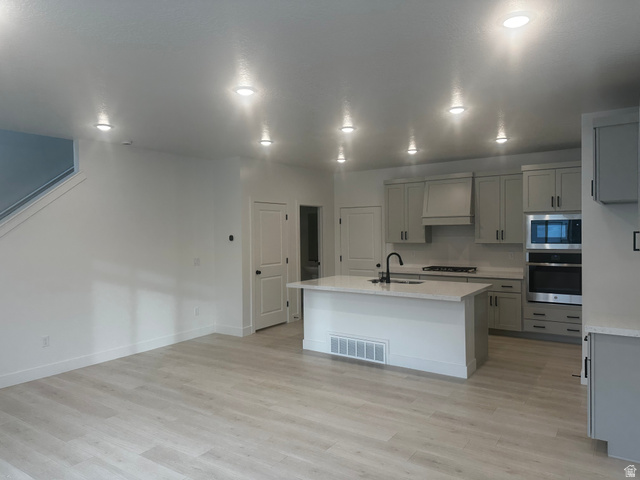 15 South Lunar Way Mapleton, UT 84664 - Photo 4 of 13 Kitchen with stainless steel appliances, gray cabinetry, an island with sink, and light wood-type flooring