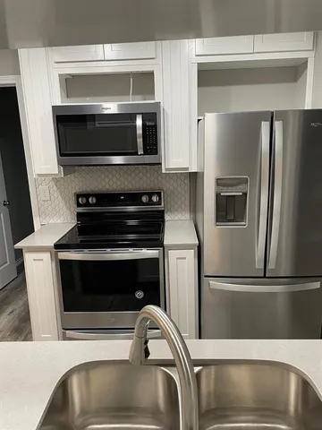 a kitchen with granite countertop a stove and a microwave