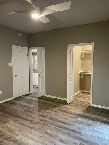 an empty room with wooden floor and closet