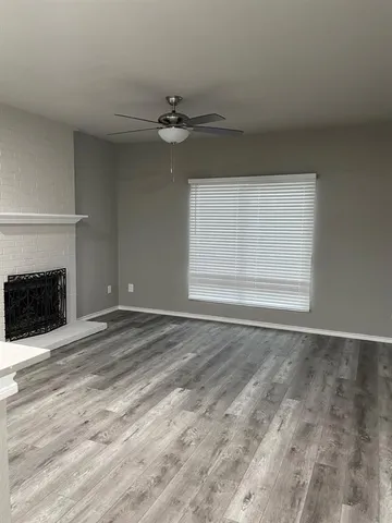 a view of an empty room with a fireplace and a window