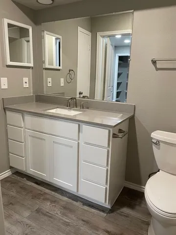 a bathroom with a toilet sink and mirror