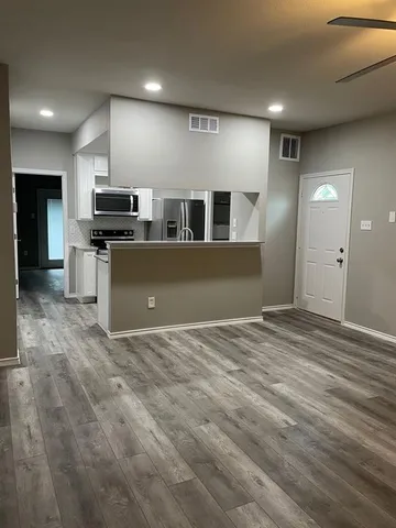a view of kitchen with kitchen island microwave and refrigerator