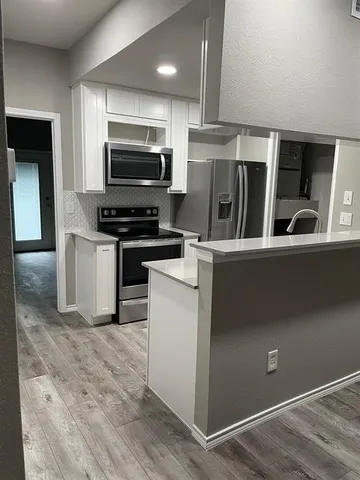 a kitchen with stainless steel appliances and a refrigerator