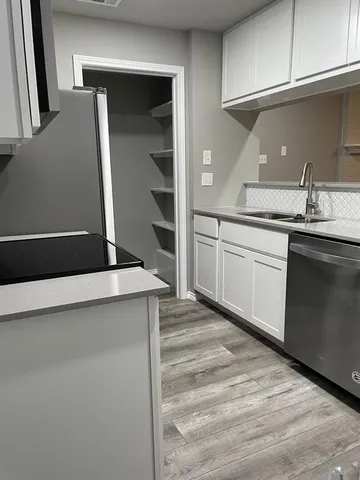 a kitchen with granite countertop a sink and cabinets