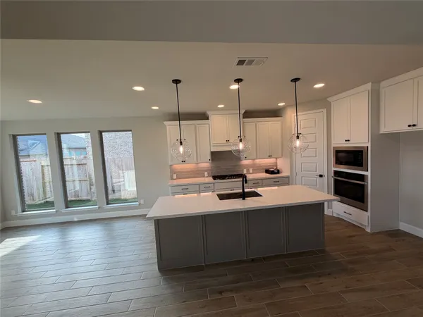 a large kitchen with a large counter top appliances and cabinets