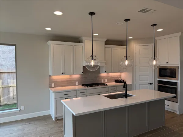 a kitchen with kitchen island a counter top space appliances and cabinets