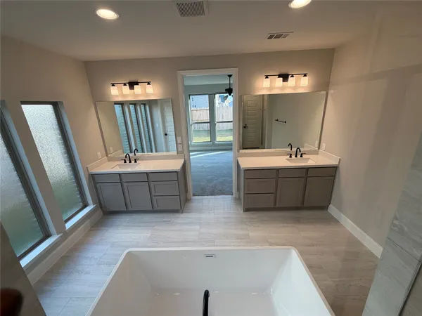 a bathroom with 2 sink tub and a mirror
