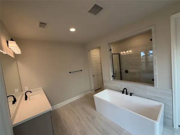 a bathroom with a tub sink and mirror