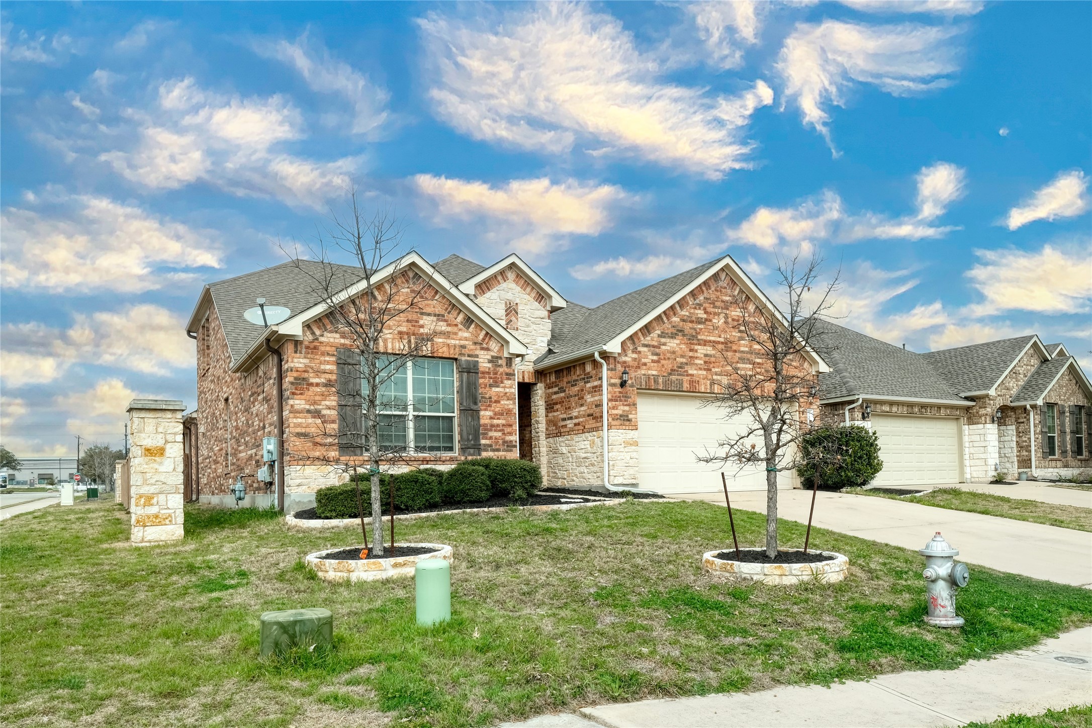1804 Elaina Loop Leander, TX 78641 - Photo 1 of 12 View of front of home with an attached garage, brick siding, concrete driveway, and a front yard