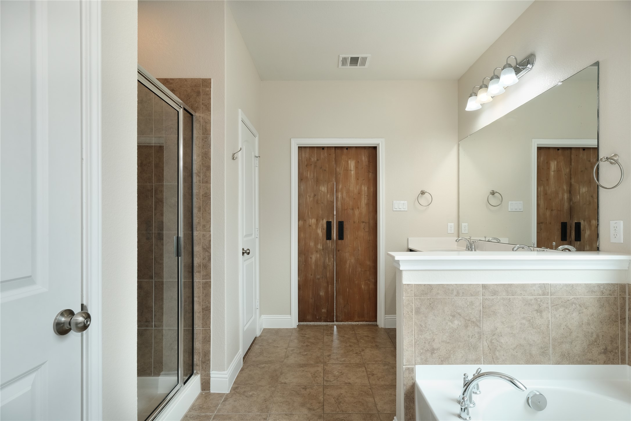 1804 Elaina Loop Leander, TX 78641 - Photo 5 of 12 Bathroom with a garden tub, a shower stall, light tile patterned floors, and vanity