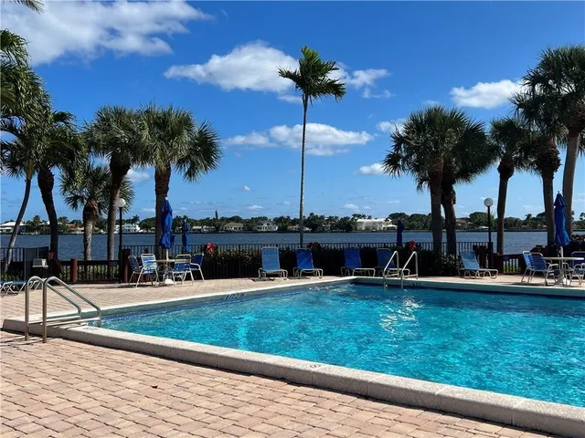 a view of a swimming pool with a slide and a palm tree