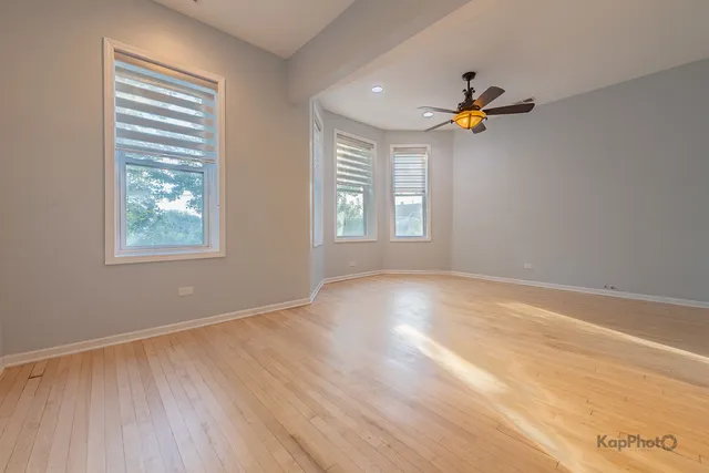 an empty room with windows and wooden floor