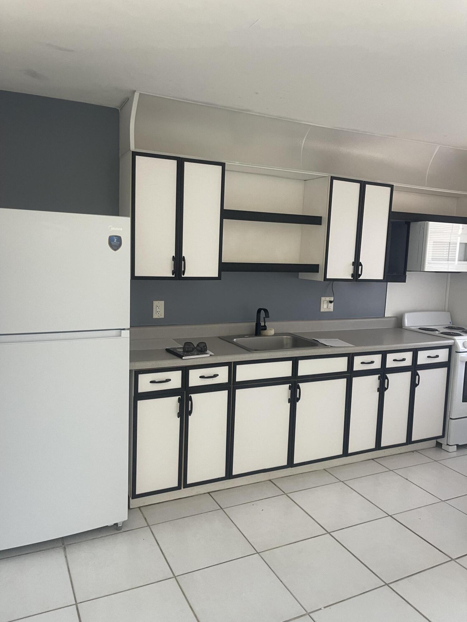 1081 Southeast Monterey Road, Unit 331 Stuart, FL 34994 - Photo 7 of 12 a kitchen with stainless steel appliances granite countertop a sink and a stove