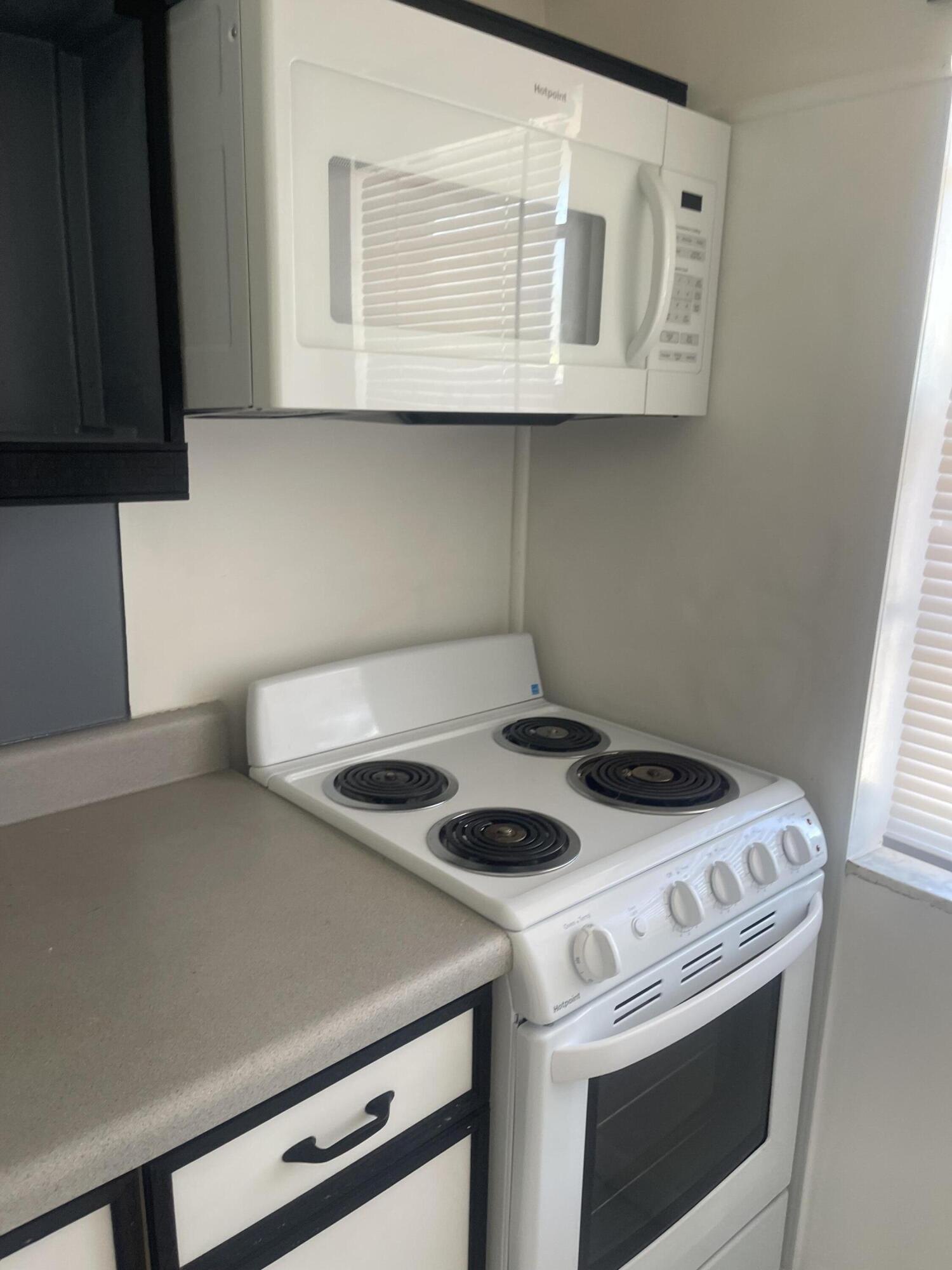 1081 Southeast Monterey Road, Unit 331 Stuart, FL 34994 - Photo 9 of 12 a kitchen with a stove and a microwave