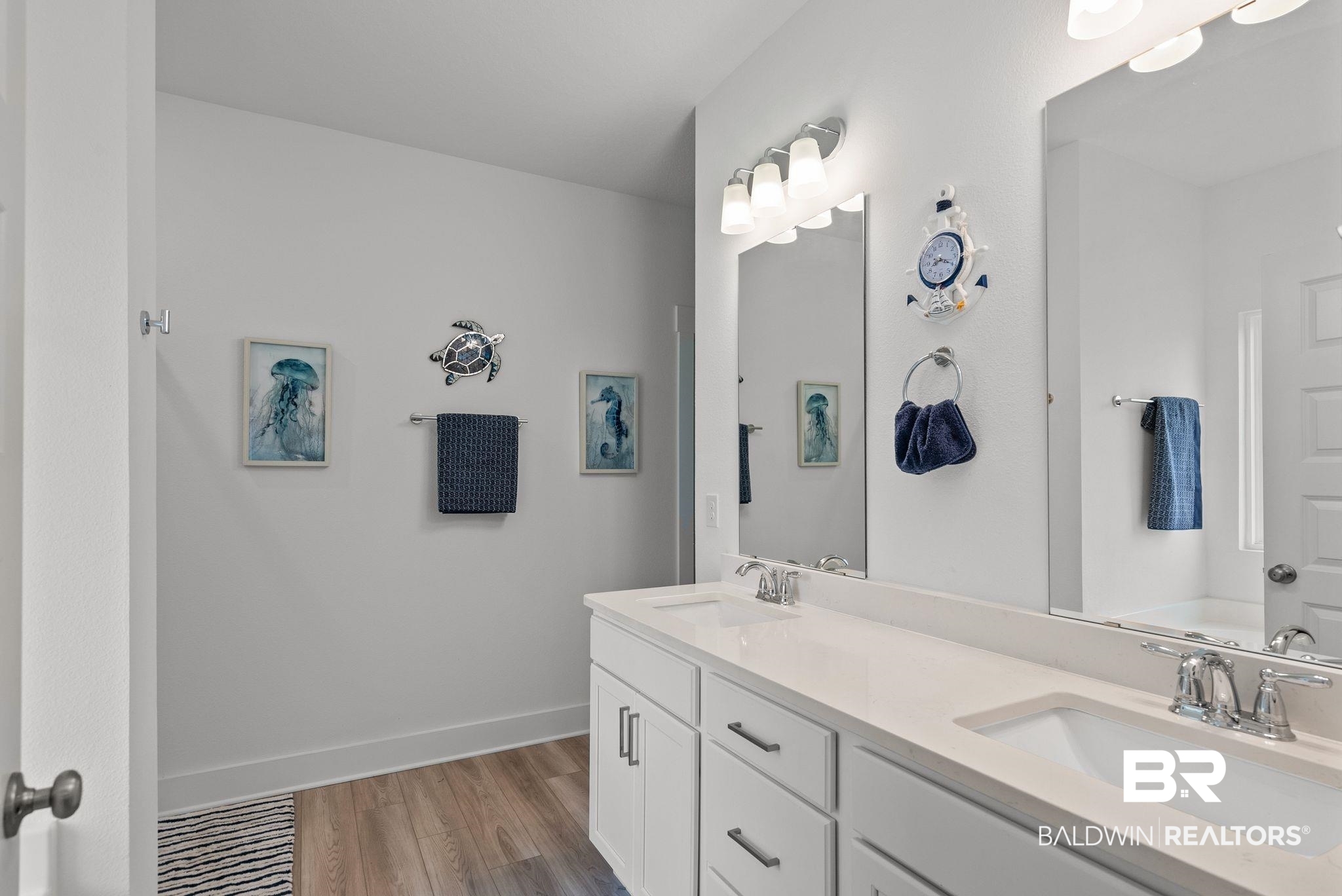 9899 Willet Way Foley, AL 36535 - Photo 19 of 37 Dual vanity with integrated sinks, white cabinetry, chrome fixtures, and wood-finish flooring
