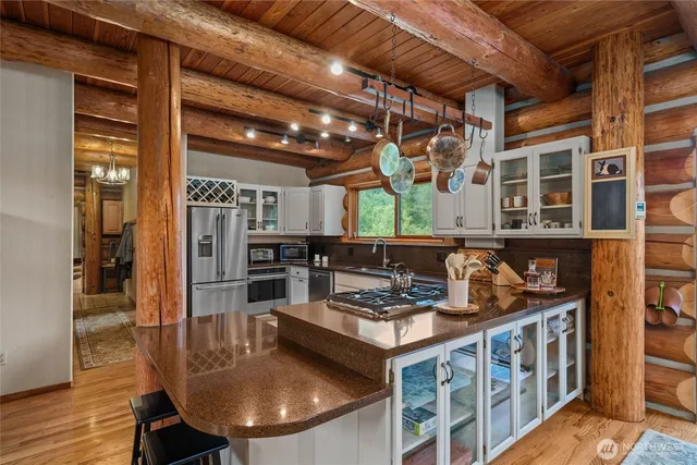 a kitchen with stainless steel appliances granite countertop a sink a stove counter space and cabinets