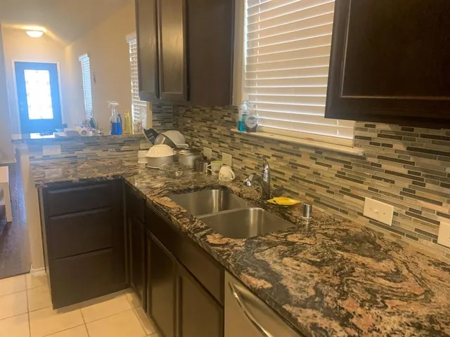a kitchen with granite countertop a sink and a stove