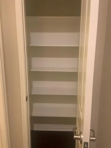 a view of walk in closet with empty racks