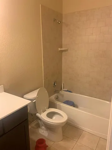 a white toilet sitting next to a white tub